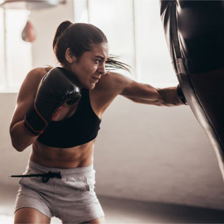 Female Boxer Punching a Punch Bag 